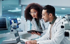 Science, teamwork and scientist with tablet in laboratory for communication, pharmaceutical review or planning. Employees, collaboration and technology for research, discussion and digital analysis