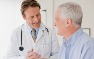 Doctor talking with patient in doctors office - stock photo