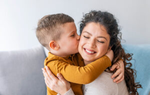 Son is kissing his mother. The kind of love that can't be described, only felt. Mom and son. Happy mother's day! Mother hugging her child