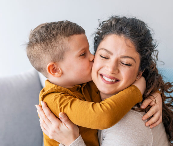 Son is kissing his mother. The kind of love that can't be described, only felt. Mom and son. Happy mother's day! Mother hugging her child