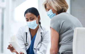 Shot of a young doctor using a digital tablet during a consultation with a senior woman.