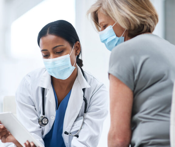 Shot of a young doctor using a digital tablet during a consultation with a senior woman.