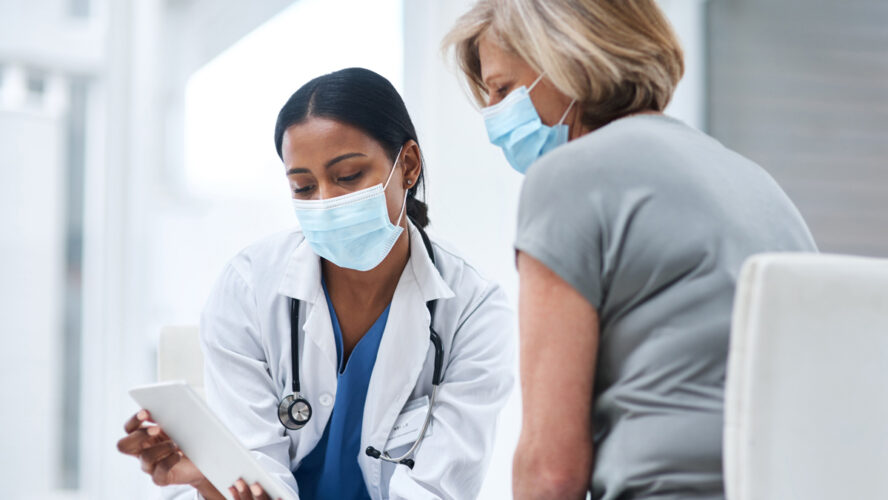 Shot of a young doctor using a digital tablet during a consultation with a senior woman.