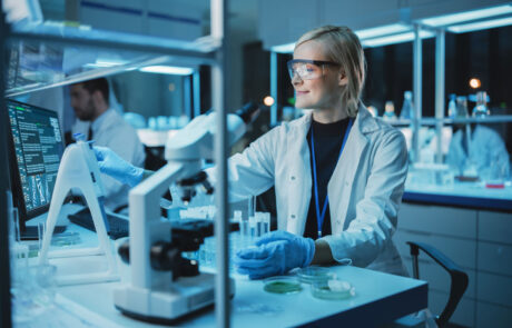 Female Research Scientist Uses Micropipette to Mix Liquids in a Sample Test Tube in a Modern Laboratory. Scientists are Conducting DNA Research with the Help of Technology, Microscopes and Computers