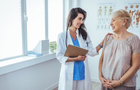 Shot of a senior woman having a consultation with her doctor. Senior woman having a doctors appointment. Doctor in blue uniform and protective face mask giving advice to Senior female patient at hospital