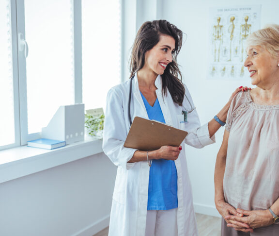 Shot of a senior woman having a consultation with her doctor. Senior woman having a doctors appointment. Doctor in blue uniform and protective face mask giving advice to Senior female patient at hospital