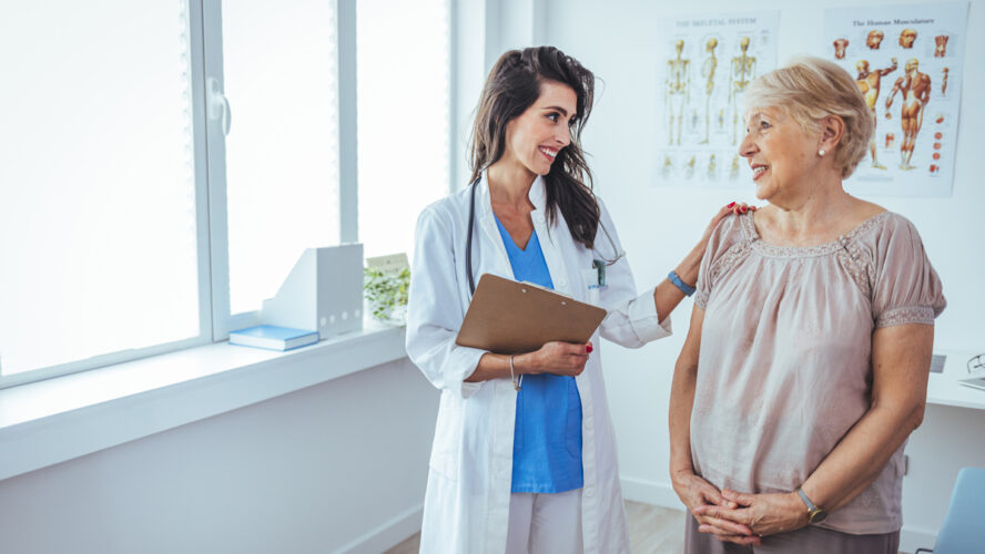 Shot of a senior woman having a consultation with her doctor. Senior woman having a doctors appointment. Doctor in blue uniform and protective face mask giving advice to Senior female patient at hospital