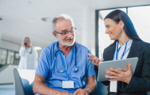 Young business woman shaking hand with elderly doctor
