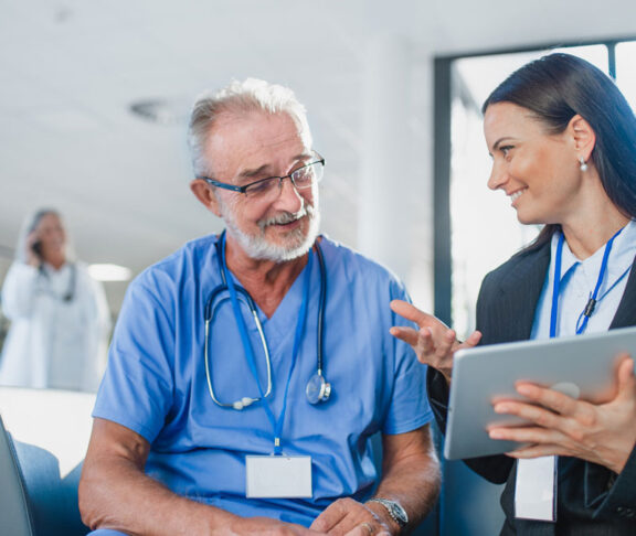 Young business woman shaking hand with elderly doctor