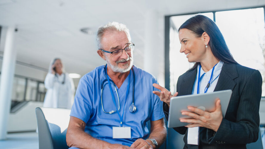 Young business woman shaking hand with elderly doctor