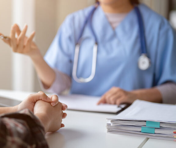 Close-up hand image of a serious patient having a medical consultation with a doctor.