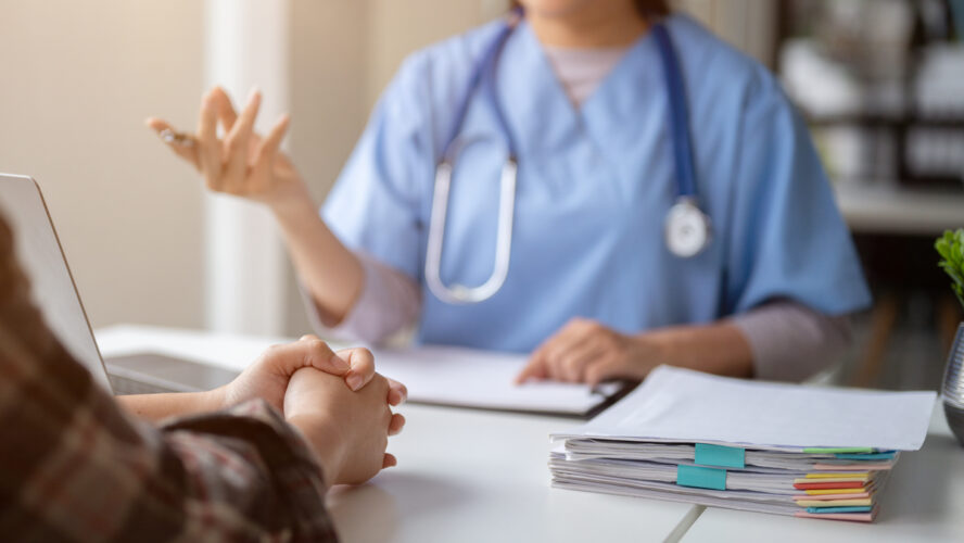 Close-up hand image of a serious patient having a medical consultation with a doctor.