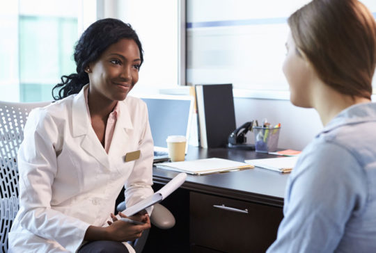 Doctor In Consultation With Female Patient In Office