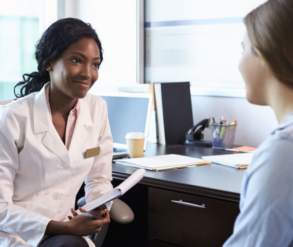 Doctor In Consultation With Female Patient In Office