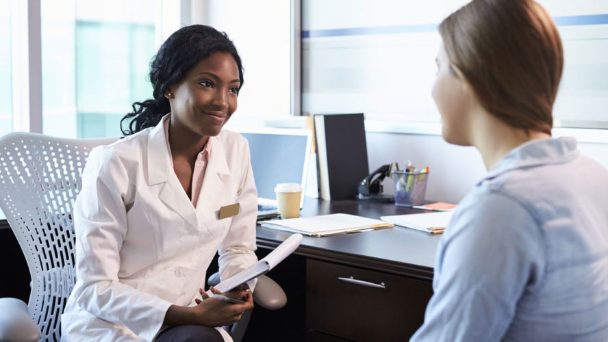 Doctor In Consultation With Female Patient In Office