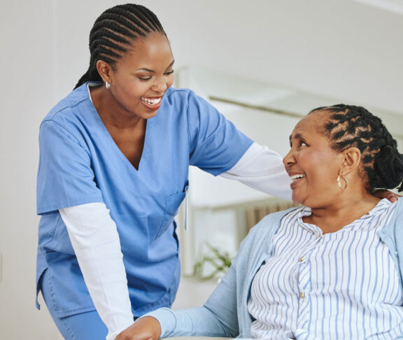 Nurse woman, senior patient and talking for support, healthcare and happiness at retirement home. Black person and happy caregiver together for trust, elderly care and help for health and wellness