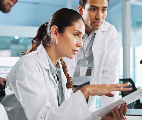 Teamwork, talking or scientists on laptop for medical breakthrough, clinical trial or DNA discovery. People, biology testing or science research in lab with results notes, bacteria or medicine cure