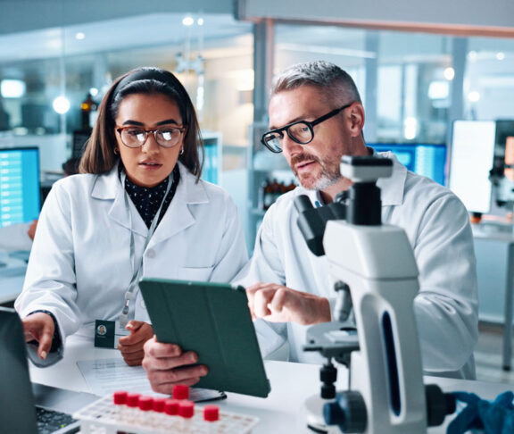 Collaboration, tablet or science with people in lab together for research or development. Innovation, tech and microscope with scientist team in clinical trial for planning or medical investigation