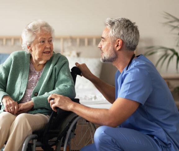 Caregiver doing regular check-up of senior woman in her home.