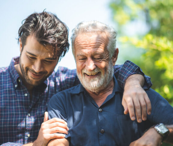 caucasian senior father and adult son are hugging together at home, generation family are happy with people love, male mature, old person man, elderly grandfather smiling living at the house