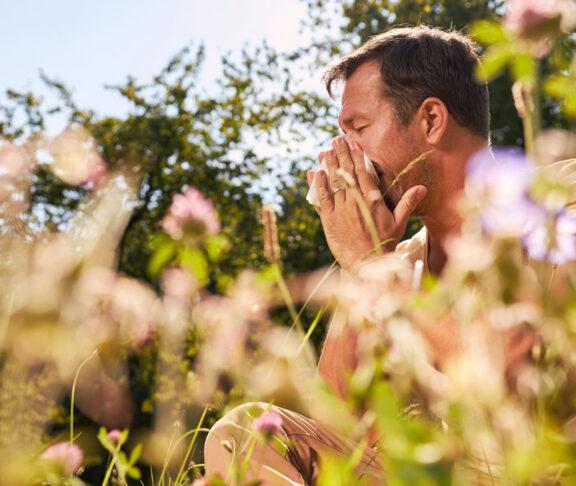 Man with hay fever blows his nose