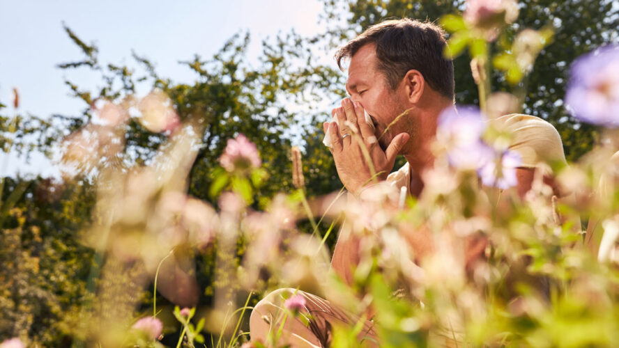 Man with hay fever blows his nose