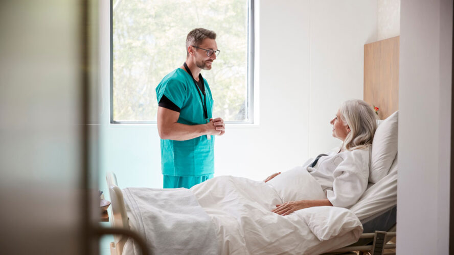 Surgeon Visiting And Talking With Mature Female Patient In Hospital Bed