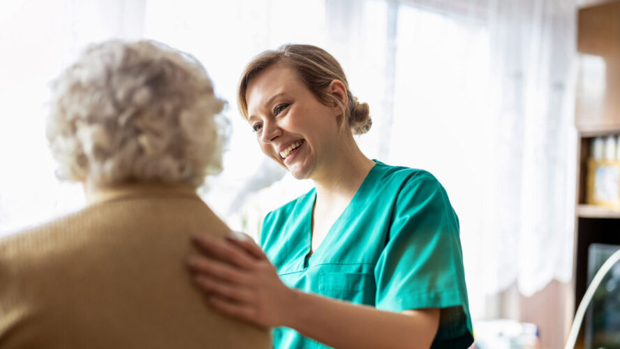 Friendly nurse supporting an elderly lady