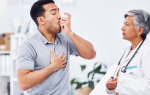 Asthma inhaler, patient and doctor with healthcare and medicine for lung disease, wellness and senior woman with man at clinic. Help, trust and care with pump for breathing, with health and drugs