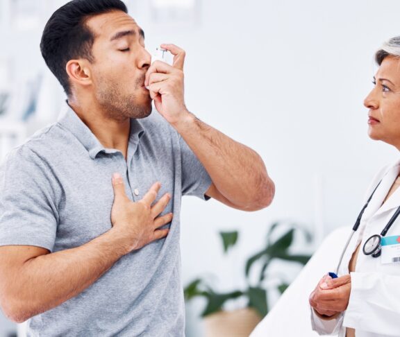 Asthma inhaler, patient and doctor with healthcare and medicine for lung disease, wellness and senior woman with man at clinic. Help, trust and care with pump for breathing, with health and drugs