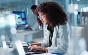 Woman. laptop and lab for research science or online internet for futuristic discovery, microscope or medicine. Female person, brainstorming and biotechnology for investigation, cure or development