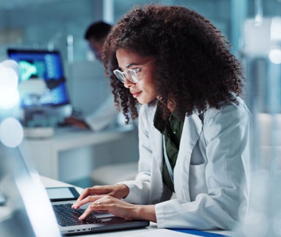 Woman. laptop and lab for research science or online internet for futuristic discovery, microscope or medicine. Female person, brainstorming and biotechnology for investigation, cure or development
