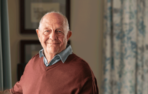 Happy senior man looking at camera at home
