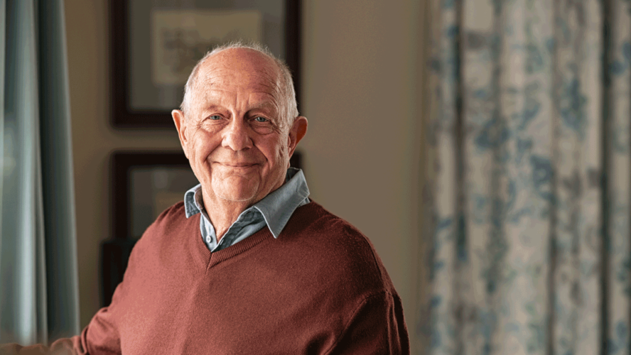 Happy senior man looking at camera at home