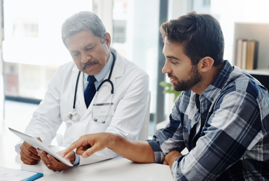 Cropped shot of a mature male doctor and patient having a discussion in the doctor's office before a checkup