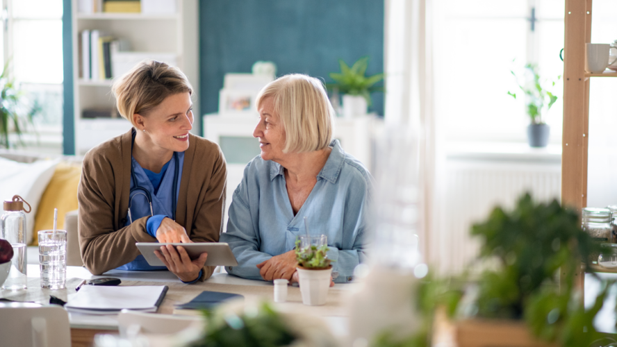 Caregiver or healthcare worker with senior woman patient, using tablet and explaining