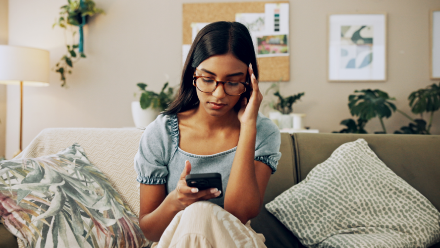 House, stress and woman with smartphone, headache and mistake with communication. Person, apartment and girl on couch, mobile user and cellphone with migraine, online reading and error message